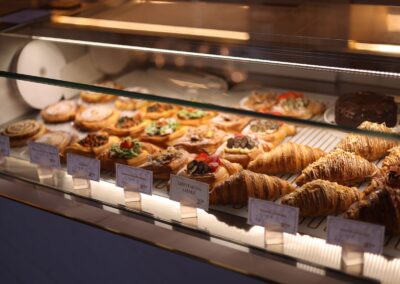 A tempting display of assorted pastries and croissants in a bakery showcase.